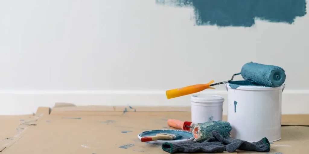 ช่างทาสีทับหน้าด้วยลูกกลิ้งบนผนังที่เตรียมพื้นผิวแล้ว เพื่อให้การทาสีทับสีเก่าเนียนติดทน